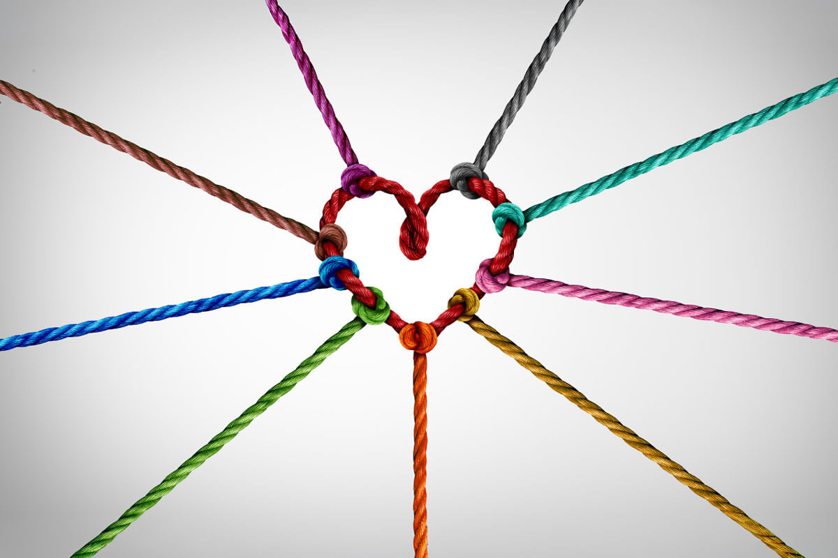 Colorful ropes of different colors tied together forming a heart shape at their center.