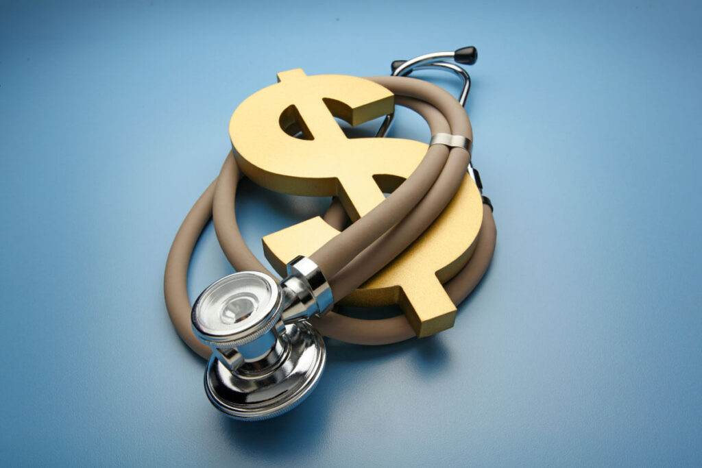 A silver stethoscope coils around a gold dollar sign against a blue background.